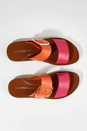 A model wearing size 37 of the Doti Double Strap Slide in colour Pinkorange (Pink), from the front, showing the whole outfit