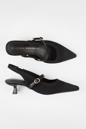 Model Genericm wearing size sample of the Kiti Heel - Black in colour Black, from an angle