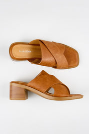 Model Genericm wearing size sample of the Meri Heel - Chocolate in colour Chocolate, from an angle