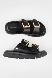 Model Genericm wearing size sample of the Toledo Sandal - Black in colour Black, in a cropped view