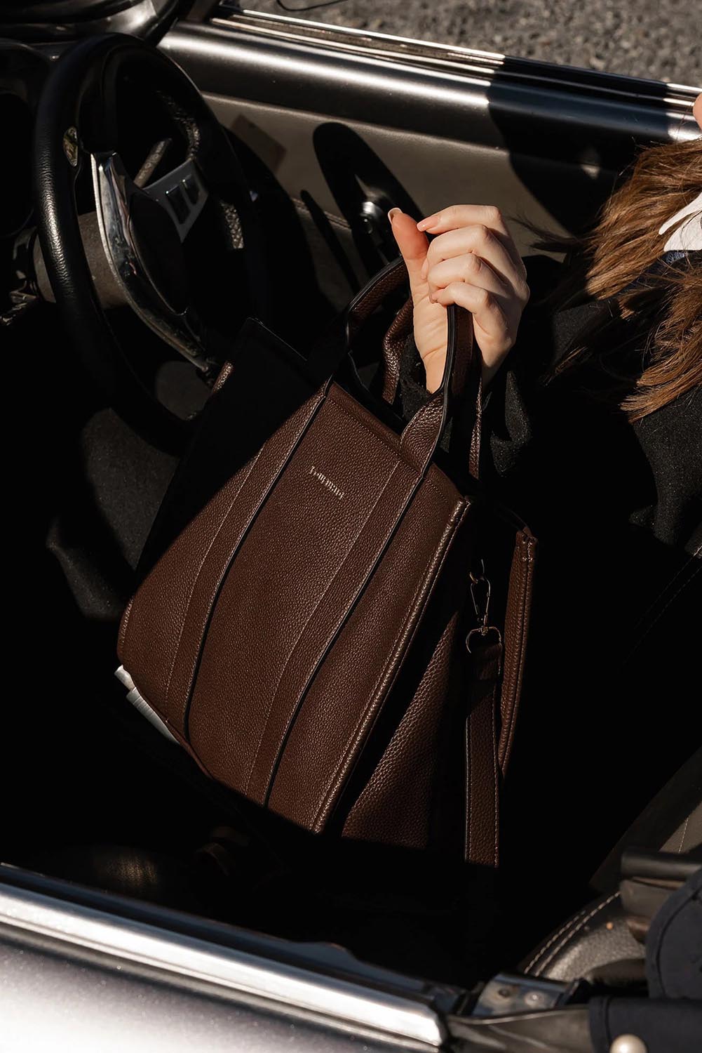A model wearing the Manhattan Tote Bag in colour Chocolate, from the front, showing the whole outfit