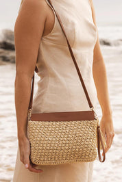 A model wearing the Fern Raffia Clutch Bag in colour Nattan, from the front, showing the whole outfit