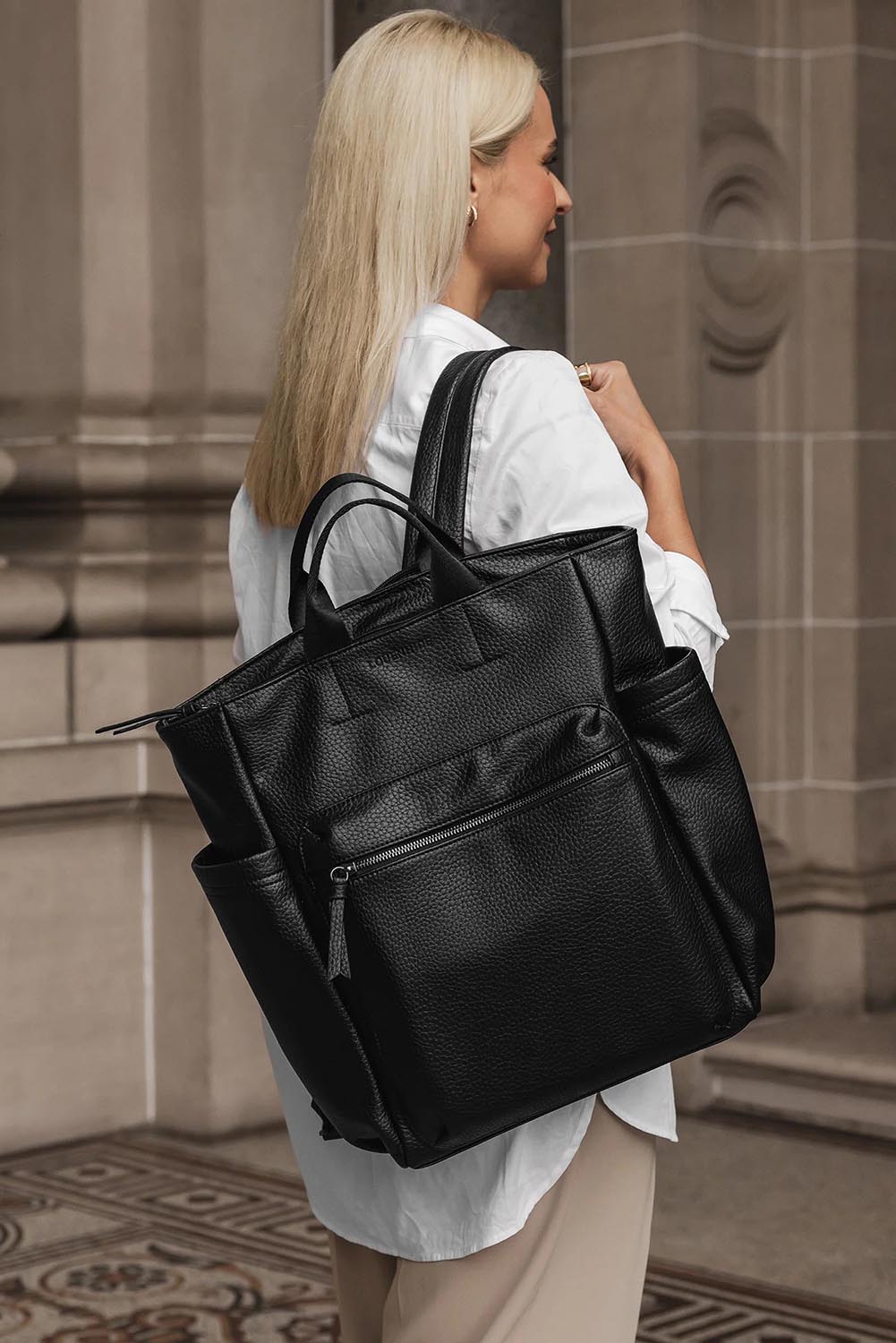 A model wearing the Bronx Backpack in colour Black (Black), from the front, showing the whole outfit