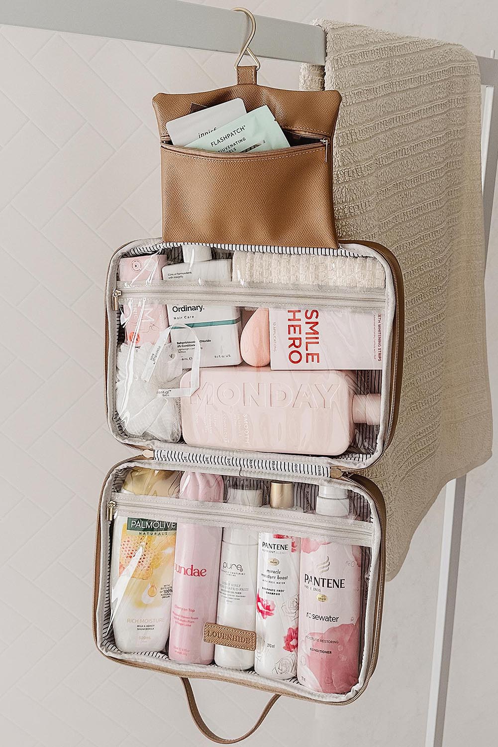 A model wearing the Baby Emma Cosmetic Case in colour Camel, from the front, showing the whole outfit