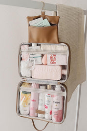 A model wearing the Baby Emma Cosmetic Case in colour Camel, from the front, showing the whole outfit