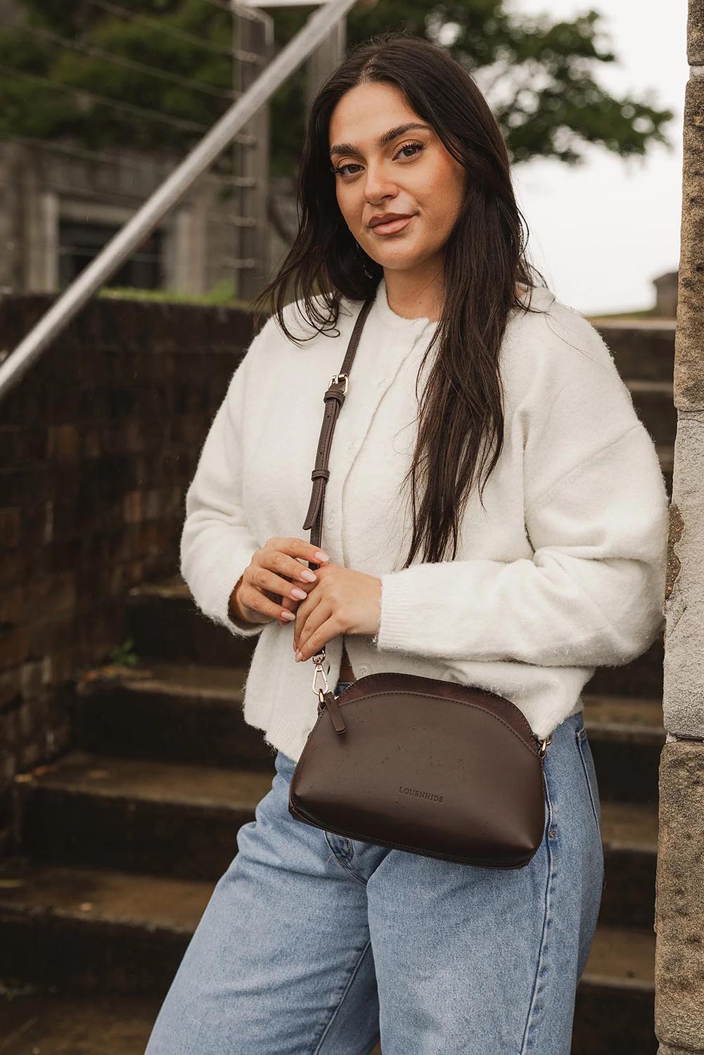 A model wearing the Alison Crossbody Handbag in colour Chocolate, from the front, showing the whole outfit