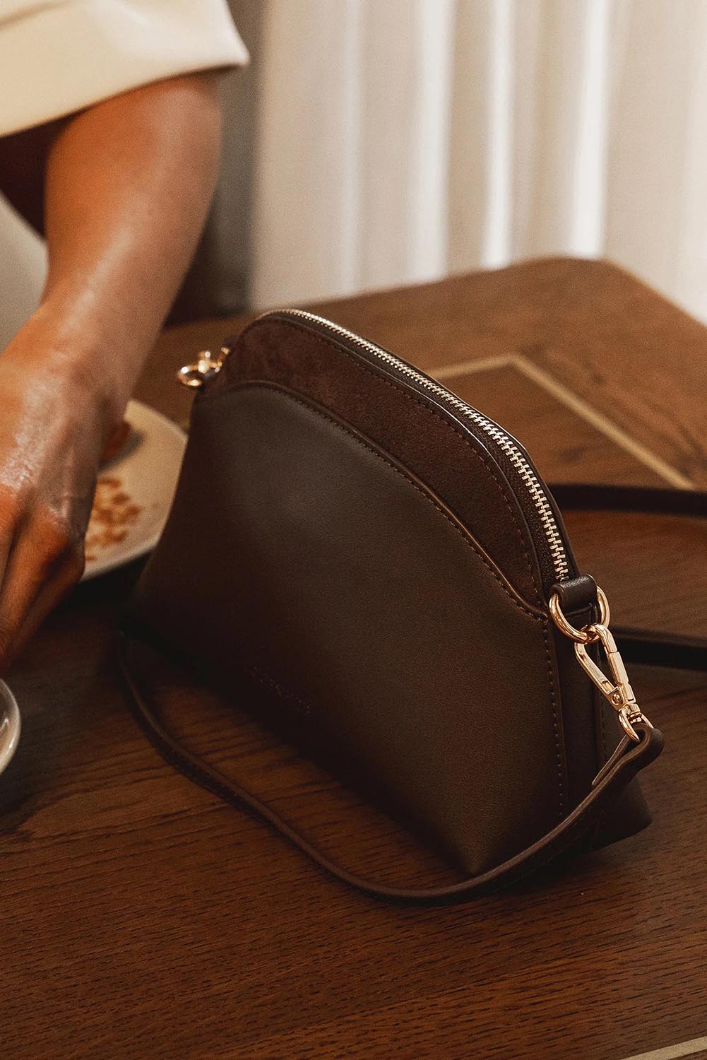 A model wearing the Alison Crossbody Handbag in colour Chocolate, from the front, showing the whole outfit