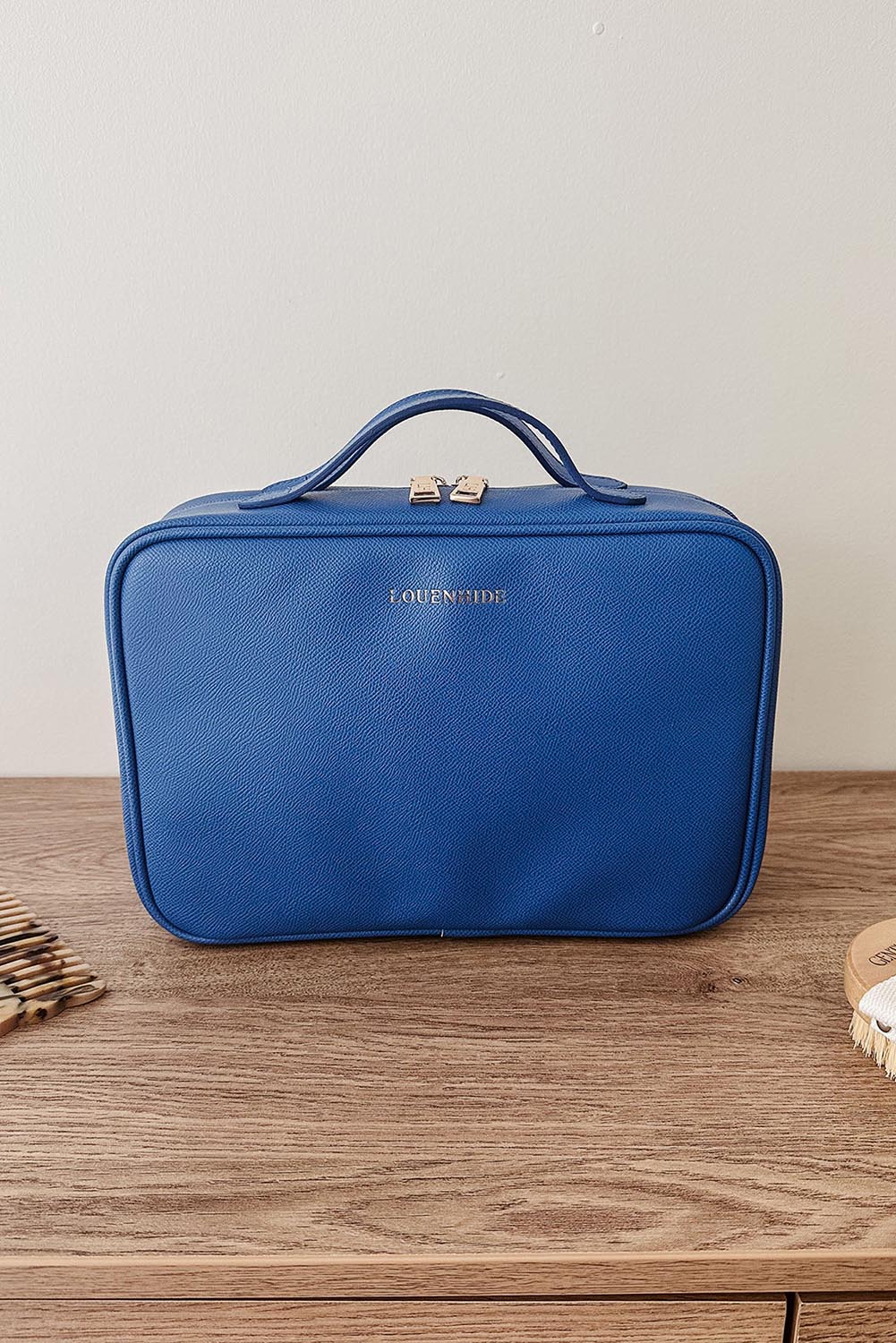 A model wearing the Georgie Toiletries Bag in colour OceanBlue (Blue), from the front, showing the whole outfit