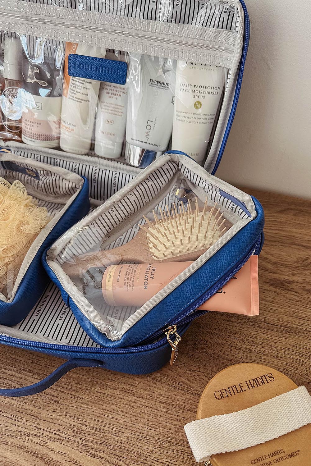 A model wearing the Georgie Toiletries Bag in colour OceanBlue (Blue), from the front, showing the whole outfit