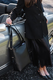 A model wearing the Audrey Shoulder Bag in colour Black (Black), from the front, showing the whole outfit