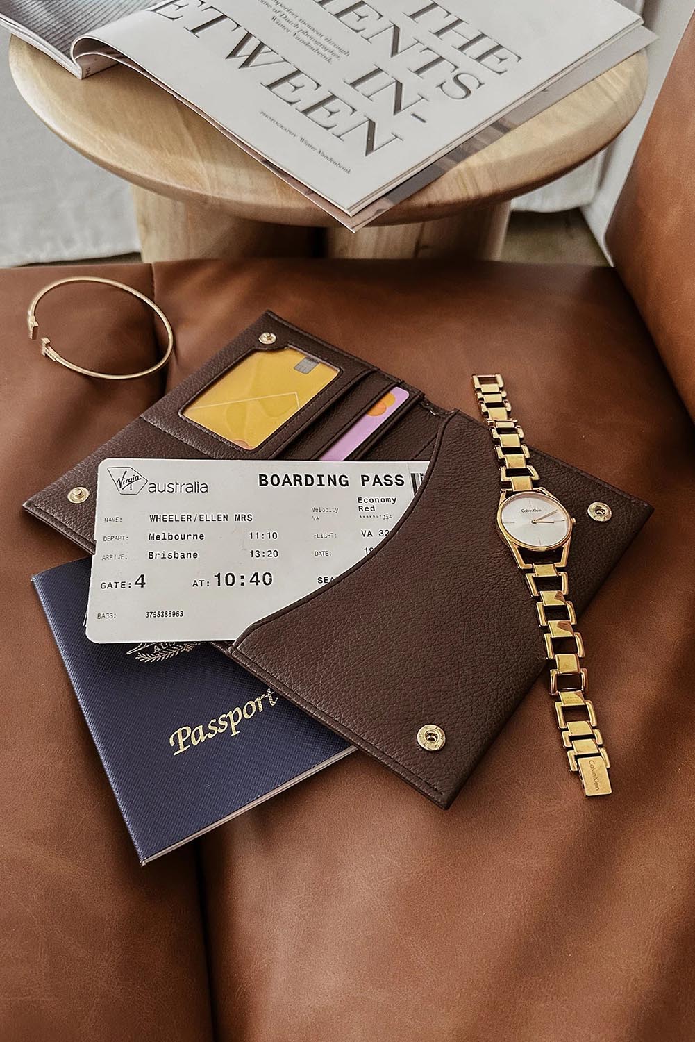 A model wearing the Venice Passport Wallet in colour Chocolate, from the front, showing the whole outfit