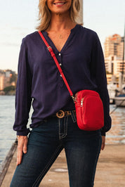 A model wearing the Java Phone Bag in colour Red (Red), from the front, showing the whole outfit