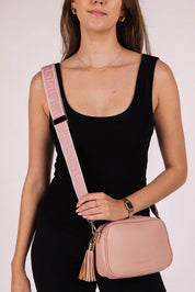 A model wearing the Jacinta Gia Crossbody Bag in colour Dustypink (Pink), from the front, cropped image