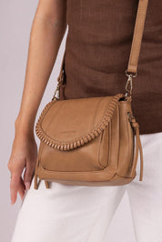 A model wearing the Shania Crossbody Bag in colour Camel, from the front, cropped image