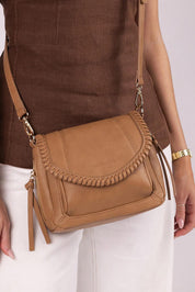 A model wearing the Shania Crossbody Bag in colour Camel, from the front, cropped image