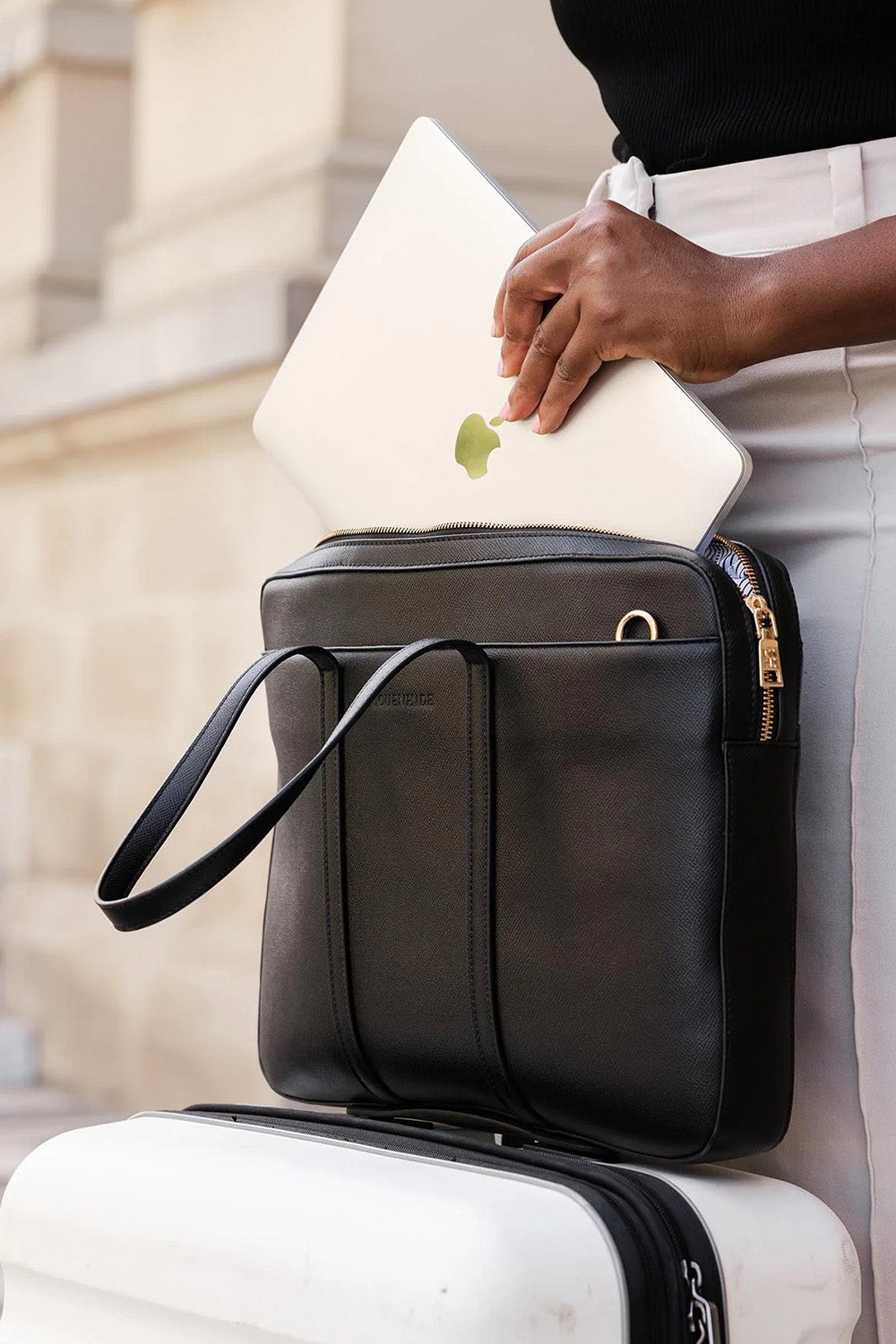 A model wearing the Orleans Laptop Bag in colour Black (Black), from the front, showing the whole outfit