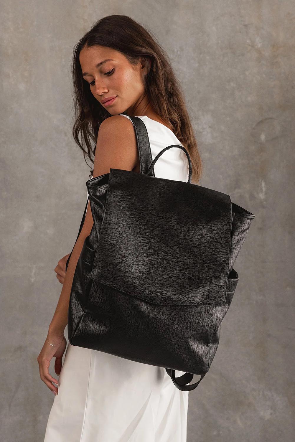 A model wearing the Drew Backpack in colour Black (Black), from the front, showing the whole outfit