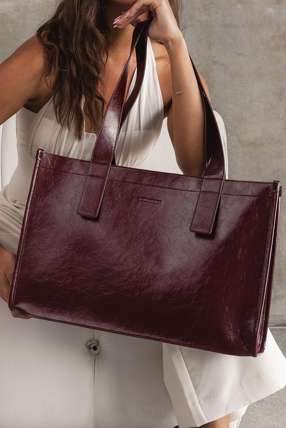 A model wearing the Riley Tote Bag in colour Burgundy (Red), from the front, showing the whole outfit