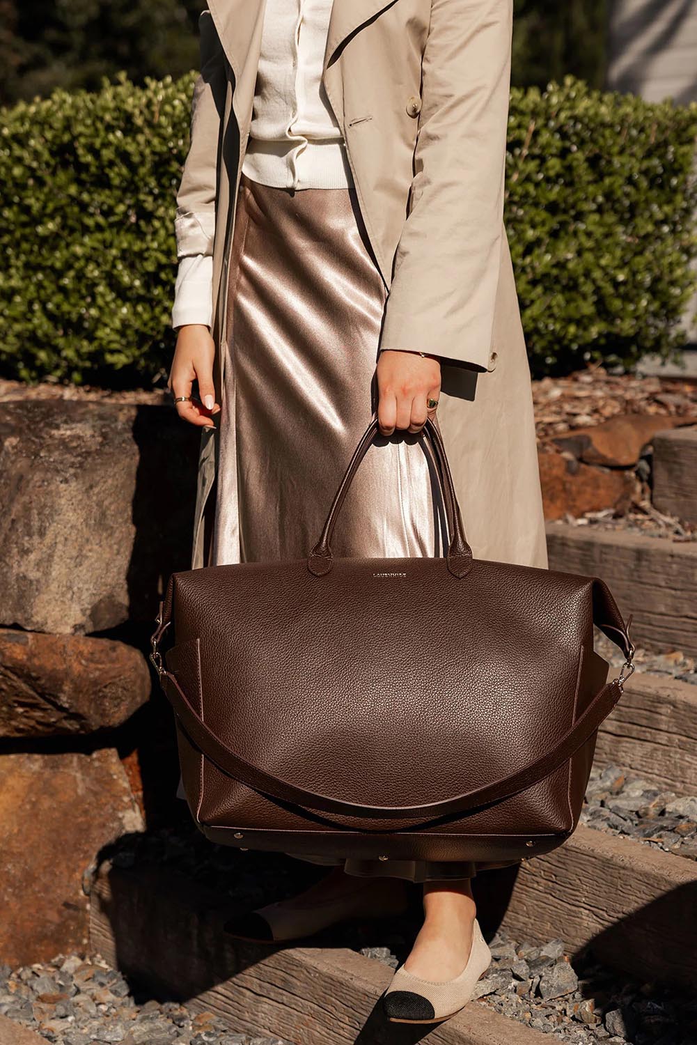 A model wearing the Ohio Overnight Bag in colour Chocolate, from the front, showing the whole outfit