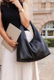 A model wearing the Monaco Shoulder Bag in colour Black (Black), from the front, showing the whole outfit