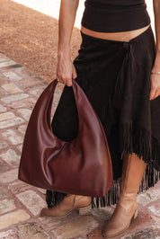 A model wearing the Monaco Shoulder Bag in colour Burgundy (Red), from the front, showing the whole outfit