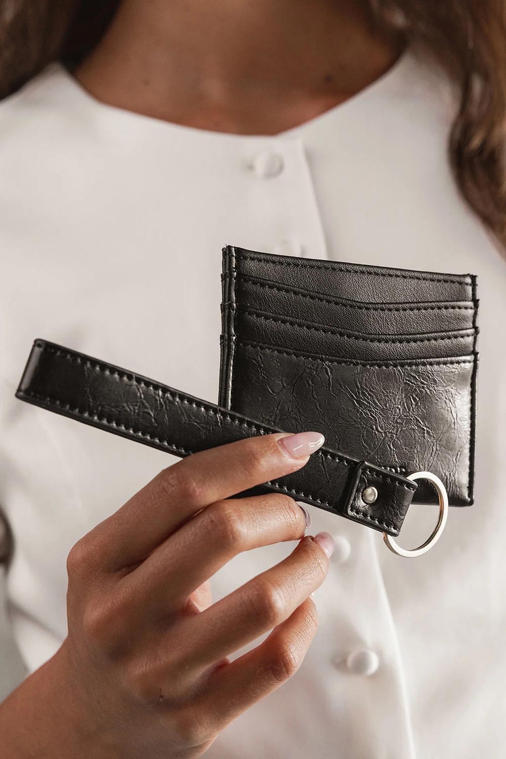 A model wearing the Ada Cardholder And Keyring in colour Blackpaten (Black), from the front, showing the whole outfit