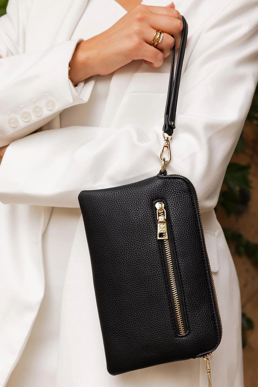 A model wearing the Poppy Clutch in colour Black (Black), from the front, showing the whole outfit