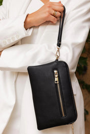 A model wearing the Poppy Clutch in colour Black (Black), from the front, showing the whole outfit