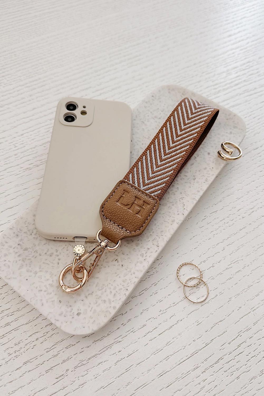 A model wearing the Iris Keyring With Phone Attachment in colour Camel, from the front, showing the whole outfit