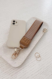 A model wearing the Iris Keyring With Phone Attachment in colour Camel, from the front, showing the whole outfit