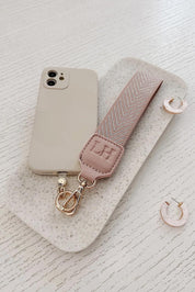 A model wearing the Iris Keyring With Phone Attachment in colour Duskypink (Pink), from the front, showing the whole outfit
