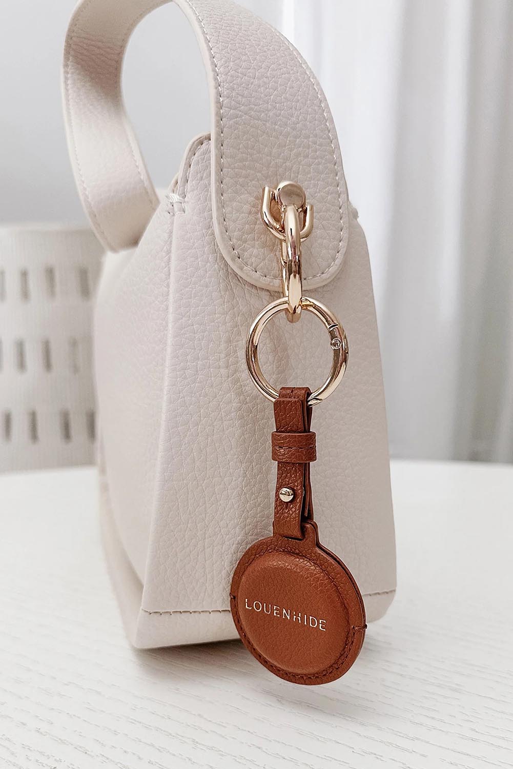 A model wearing the Opal Airtag Holder in colour Tan, from the front, showing the whole outfit