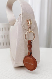 A model wearing the Opal Airtag Holder in colour Tan, from the front, showing the whole outfit