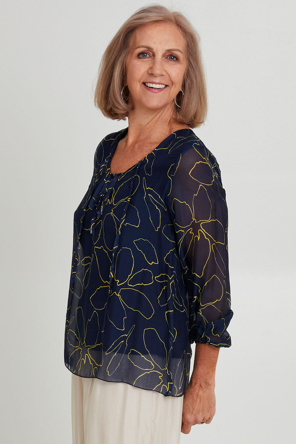 Model Sandy wearing the Silk Blend Vin colourNeck Tied Top - Navyflower (Blue), from the front, cropped image