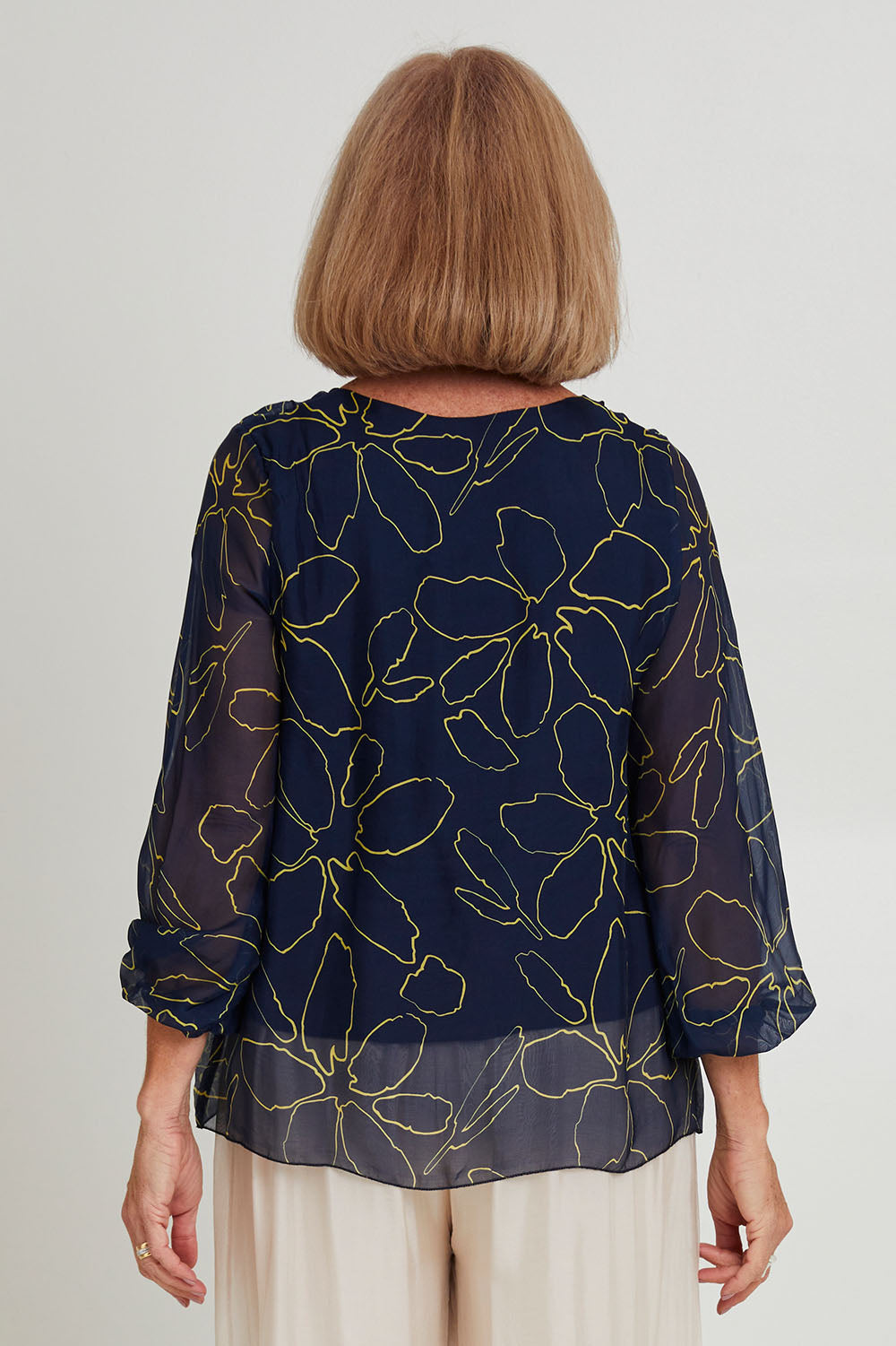 Model Sandy wearing the Silk Blend Vin colourNeck Tied Top - Navyflower (Blue), from the front, cropped image