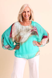 Model Sandys wearing size 10 of the Silk Blend Flounce Sleeve Top - Blueturqprint in colour Blueturqprint, in a cropped view
