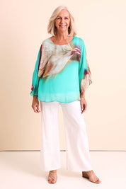 Model Sandys wearing size 10 of the Silk Blend Flounce Sleeve Top - Blueturqprint in colour Blueturqprint, from the front