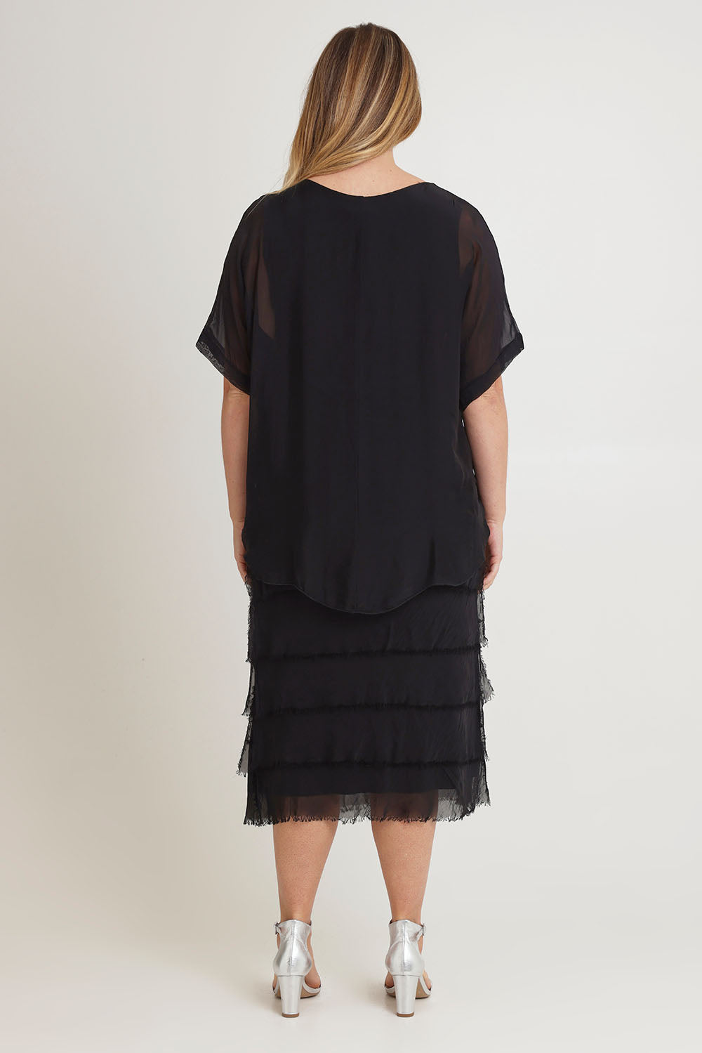 Model Chanel wearing the Silk Blend Multi Layers Dress in colour Black (Black), from the back