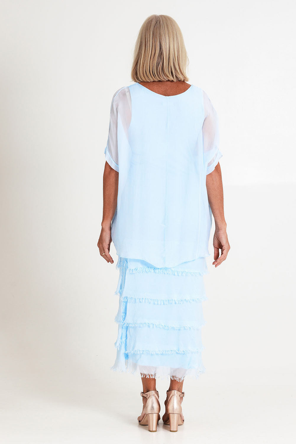 Model Sandy wearing the Silk Blend Multi Layers Dress in colour Celeste (Blue), from the back