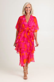 Model Sandy wearing the Short Sleeve Silk Blend Print Dress in colour Orangepink (Pink), from the front, showing the whole outfit