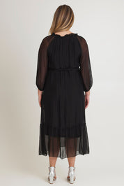 Model Chanel wearing the Long Sleeve Silk Frill Tied Neck Dress in colour Black (Black), from the back
