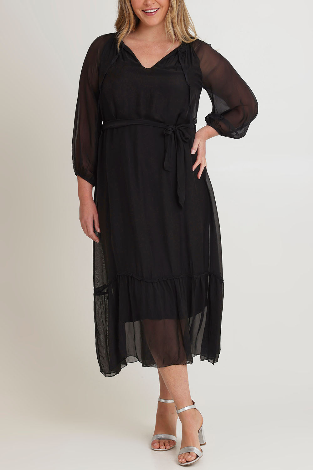 Model Chanel wearing the Long Sleeve Silk Frill Tied Neck Dress in colour Black (Black), from the front, cropped image