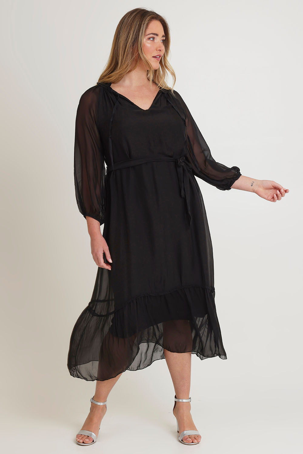 Model Chanel wearing the Long Sleeve Silk Frill Tied Neck Dress in colour Black (Black), from the front, showing the whole outfit