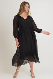 Model Chanel wearing the Long Sleeve Silk Frill Tied Neck Dress in colour Black (Black), from the front, showing the whole outfit