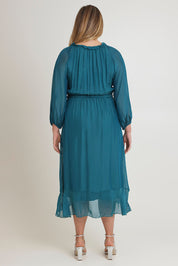 Model Chanel wearing the Long Sleeve Silk Frill Tied Neck Knee Length Dress in colour Teal (Green), from the back
