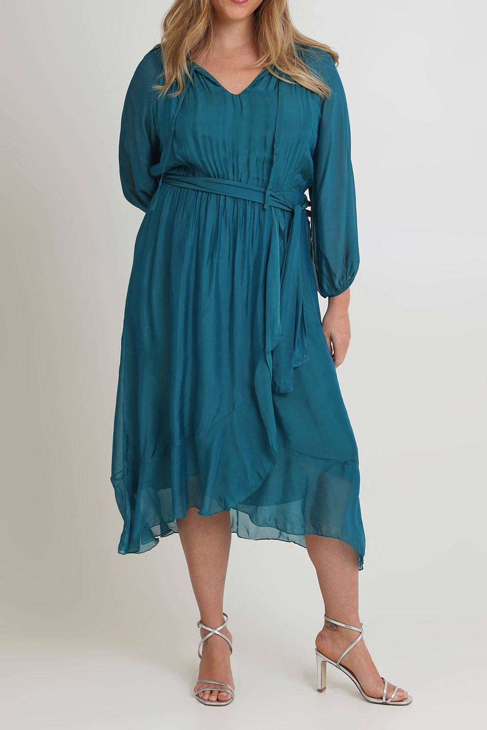 Model Chanel wearing the Long Sleeve Silk Frill Tied Neck Knee Length Dress in colour Teal (Green), from the front, cropped image