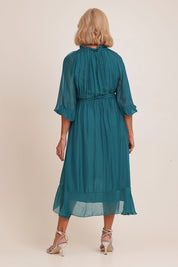 Model Sandy wearing the Long Sleeve Silk Frill Tied Neck Knee Length Dress in colour Teal (Green), from the back
