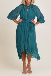 Model Sandy wearing the Long Sleeve Silk Frill Tied Neck Knee Length Dress in colour Teal (Green), from the front, cropped image