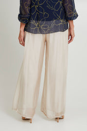 Model Sandy wearing the Silk Pant in colour Beige, from the back
