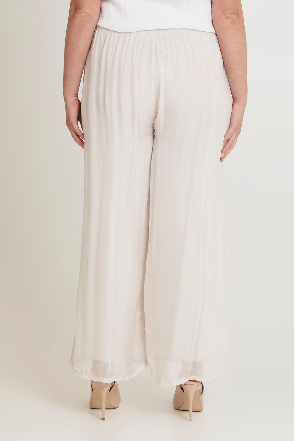 Model Chanel wearing the Silk Pant in colour Ivory, from the back